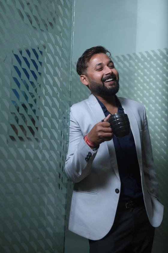 Abhieshek Katiyaar financial advisor and real estate consultant smiling with coffee cup in office