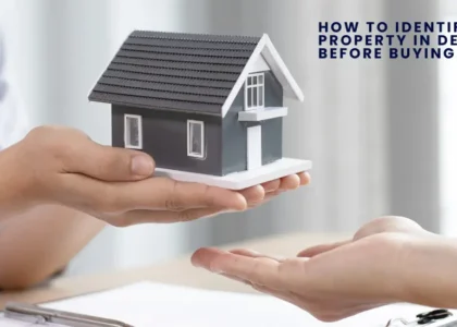 A person hands over a small model of a house to another person, symbolizing a real estate transaction, with the text "How to Identify High ROI Property in Delhi NCR Before Buying" in the background.